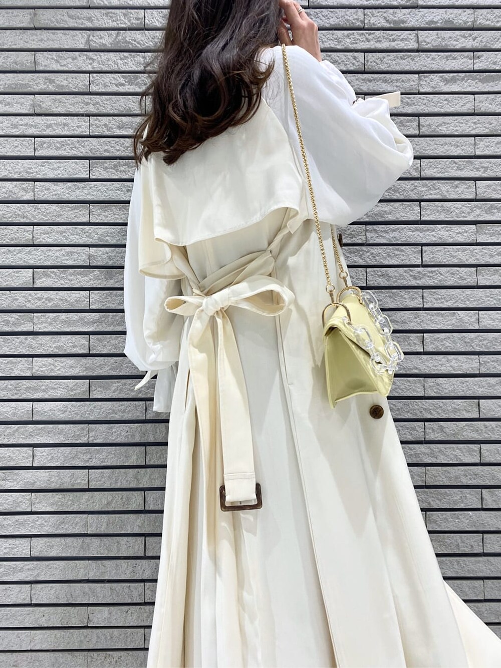 ホワイト系のその他アウター、イエロー系のショルダーバッグ、ベージュ系のワンピースを着用したレディースの冬コーディネートの7枚目の写真