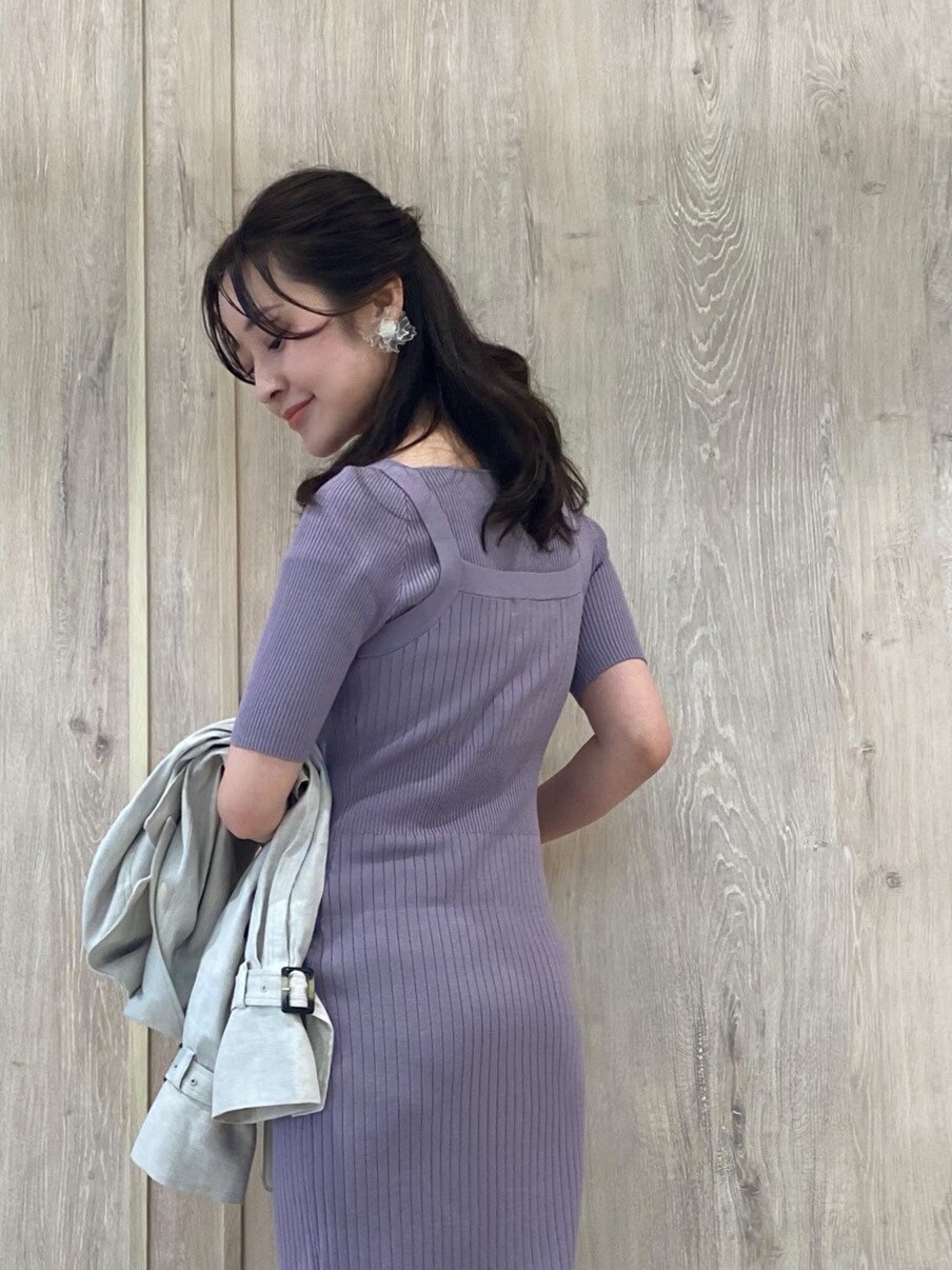 パープル系のワンピース、ホワイト系のブーツ、ホワイト系のハンドバッグを着用したレディースの冬コーディネートの6枚目の写真