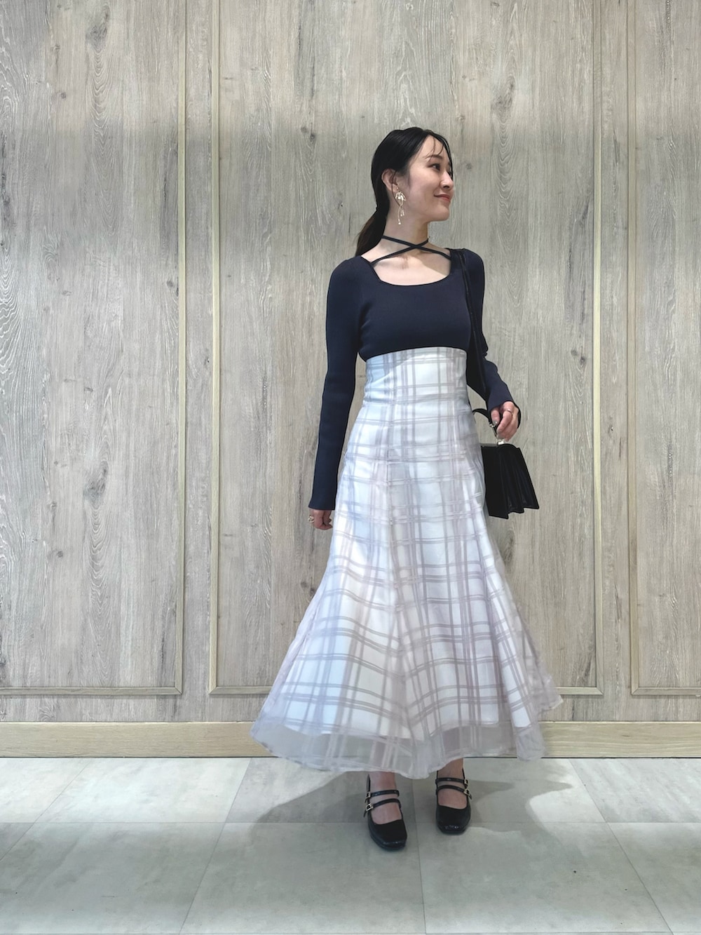 レッド系のハンドバッグ、ブラウン系のパンプス、グレー系のワンピースを着用したレディースの秋コーディネートの2枚目の写真