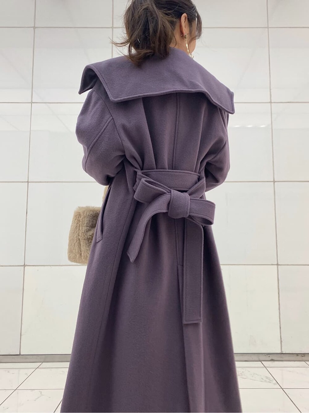 ベージュ系のパンプス、パープル系のチェスターコート、ホワイト系のニット/セーターを着用したレディースの冬コーディネートの4枚目の写真