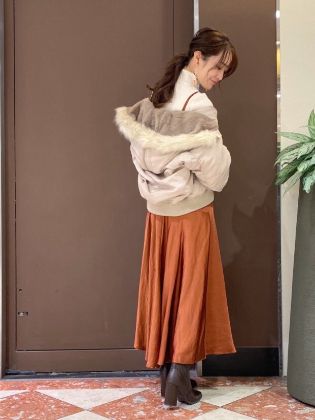 ベージュ系のブルゾン、ホワイト系のニット/セーター、ゴールド系のイヤリングを着用したレディースの秋コーディネートの2枚目の写真