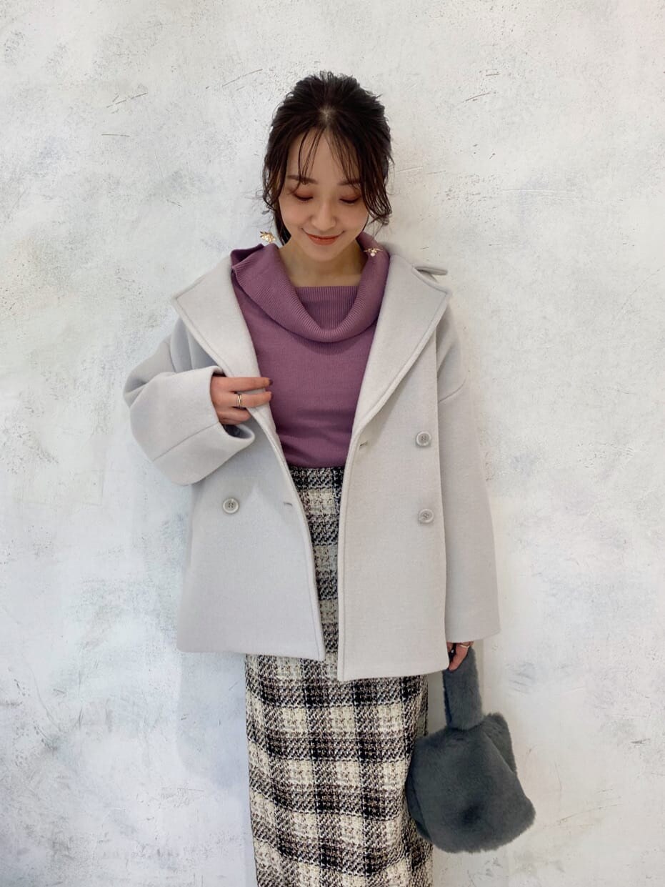 グリーン系のブルゾン、ピンク系のニット/セーター、ホワイト系のブーツを着用したレディースの秋コーディネートの3枚目の写真