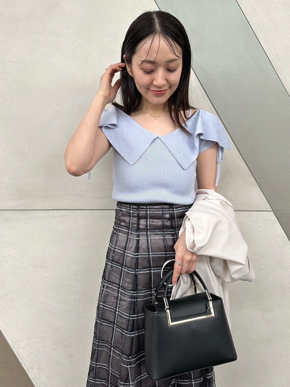 その他のサンダル、ブラック系のハンドバッグ、ブルー系のニット/セーターを着用したレディースの春コーディネートの4枚目の写真