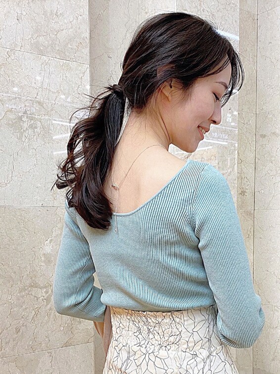 グリーン系のニット/セーター、ベージュ系のスカートを着用したレディースの冬コーディネートの6枚目の写真