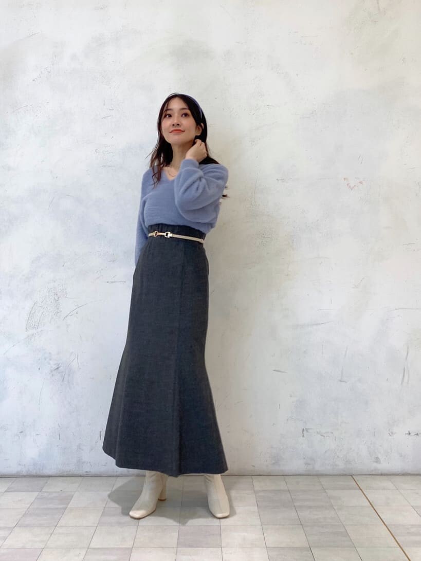 ホワイト系のブーツ、グレー系のスカート、ブルー系のニット/セーターを着用したレディースの秋コーディネートの2枚目の写真