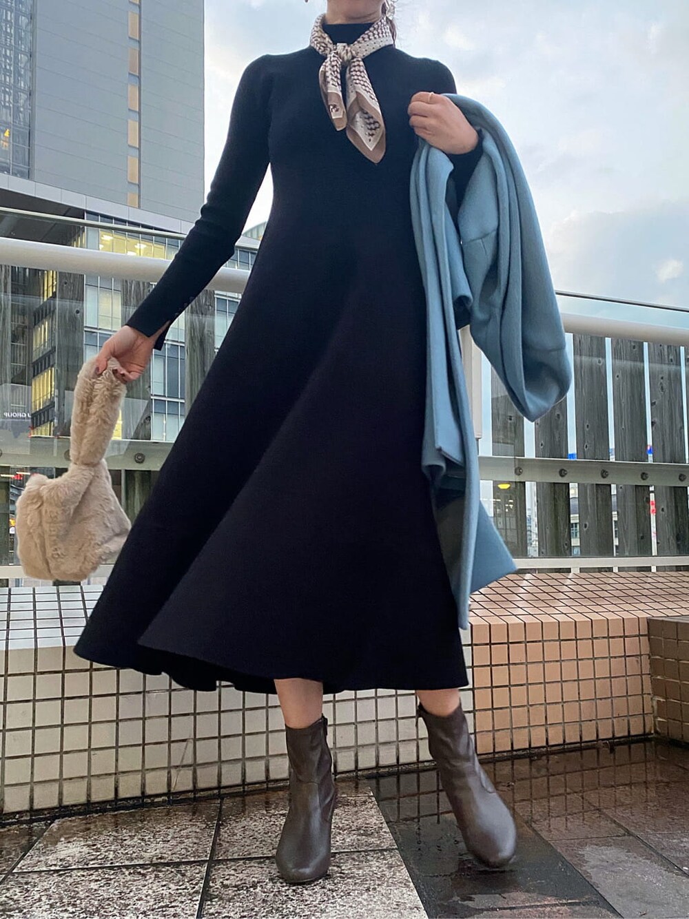 ブラウン系のその他シューズ、ブルー系のノーカラーコート、ブラック系のワンピースを着用したレディースの秋コーディネートの2枚目の写真