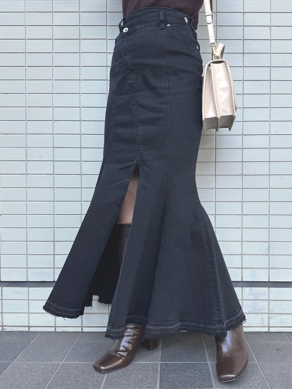 ベージュ系のショルダーバッグ、ブラック系のデニムスカート、ブラウン系のニット/セーターを着用したレディースの秋コーディネートの8枚目の写真