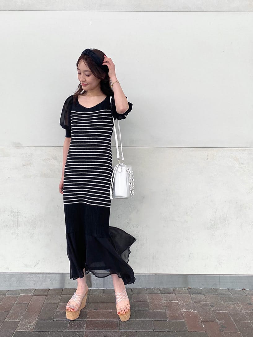 ブラック系のTシャツ/カットソー、ホワイト系のハンドバッグ、その他のサンダルを着用したレディースの春コーディネートの2枚目の写真
