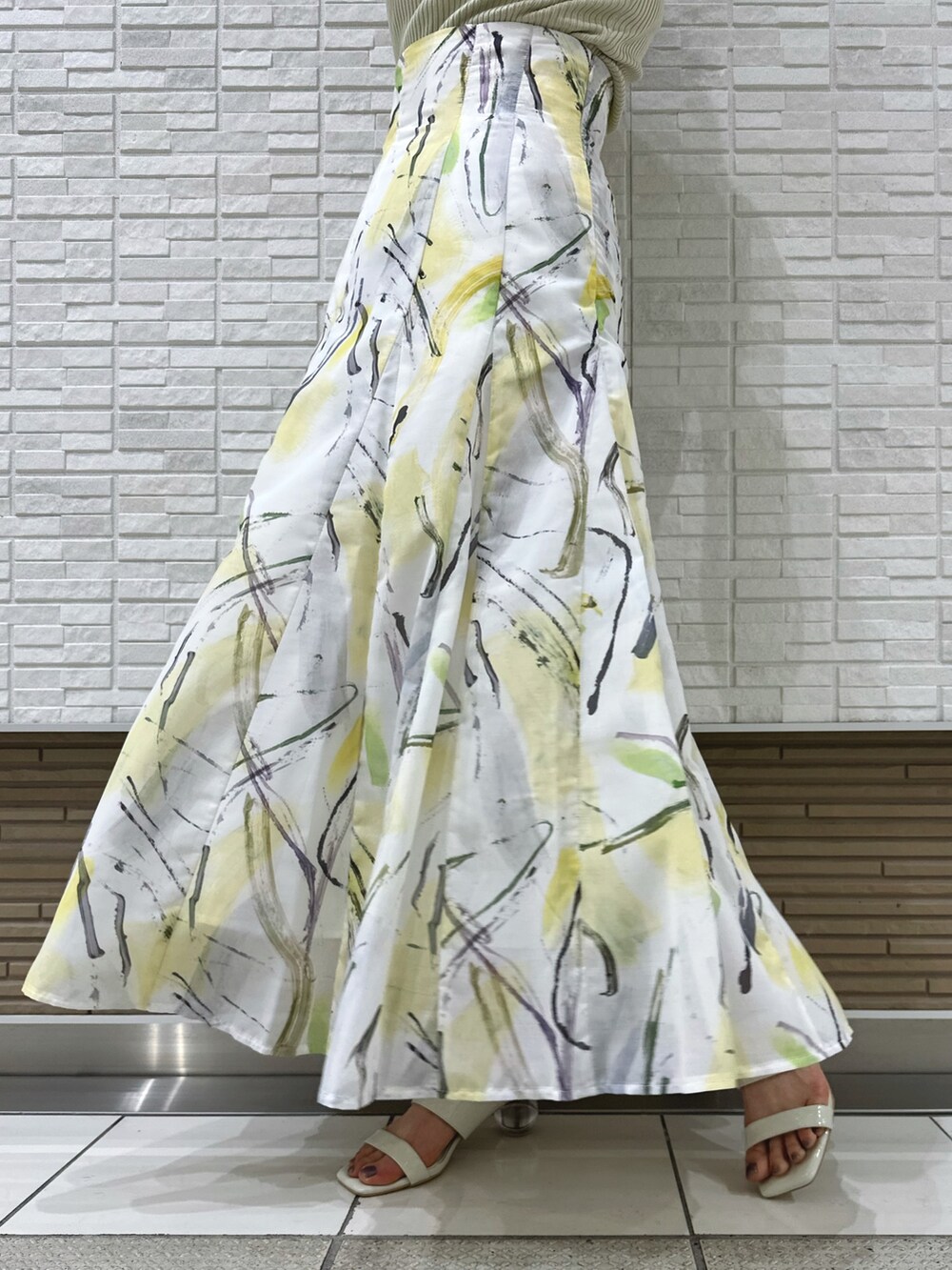 ホワイト系のキャミソール、ホワイト系のサンダル、イエロー系のスカートを着用したレディースの夏コーディネートの8枚目の写真