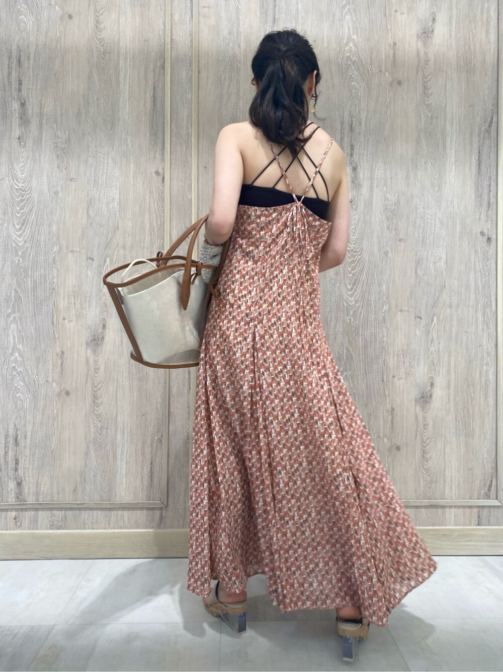 ブラウン系のトートバッグ、ベージュ系のカーディガン/ボレロ、オレンジ系のワンピースを着用したレディースの春コーディネートの8枚目の写真