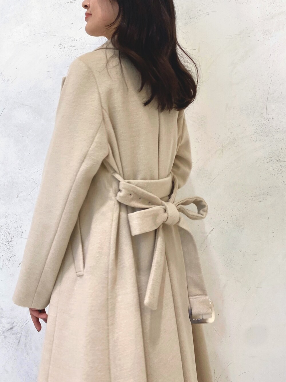 ホワイト系のワンピース、ベージュ系のブーツ、ベージュ系のチェスターコートを着用したレディースの冬コーディネートの6枚目の写真