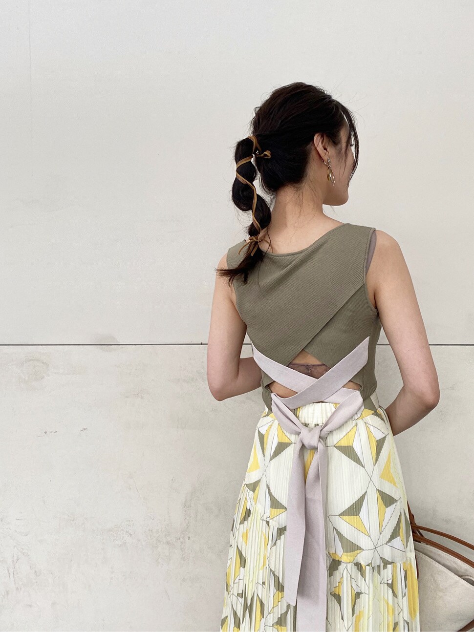 ブラウン系のトートバッグ、ベージュ系のサンダル、イエロー系のスカートを着用したレディースの夏コーディネートの5枚目の写真