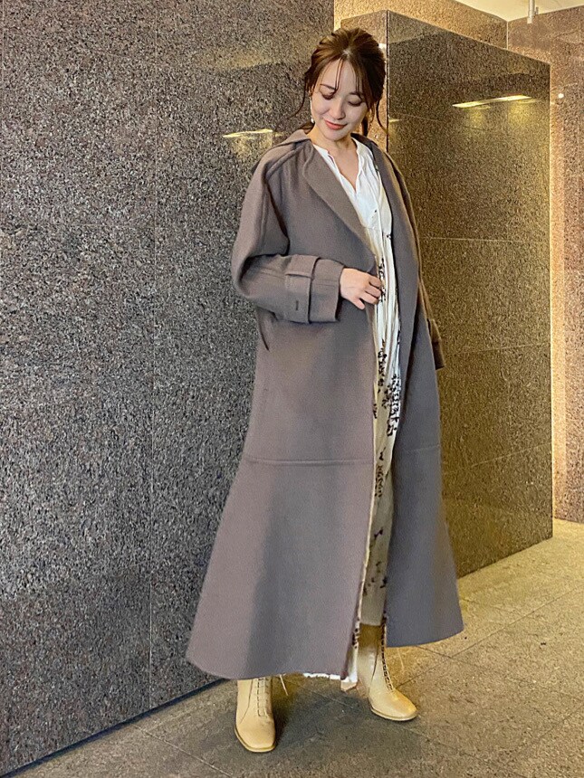 ベージュ系のワンピース、ホワイト系のシャツ/ブラウス、ベージュ系のクラッチバッグを着用したレディースの秋コーディネートの6枚目の写真