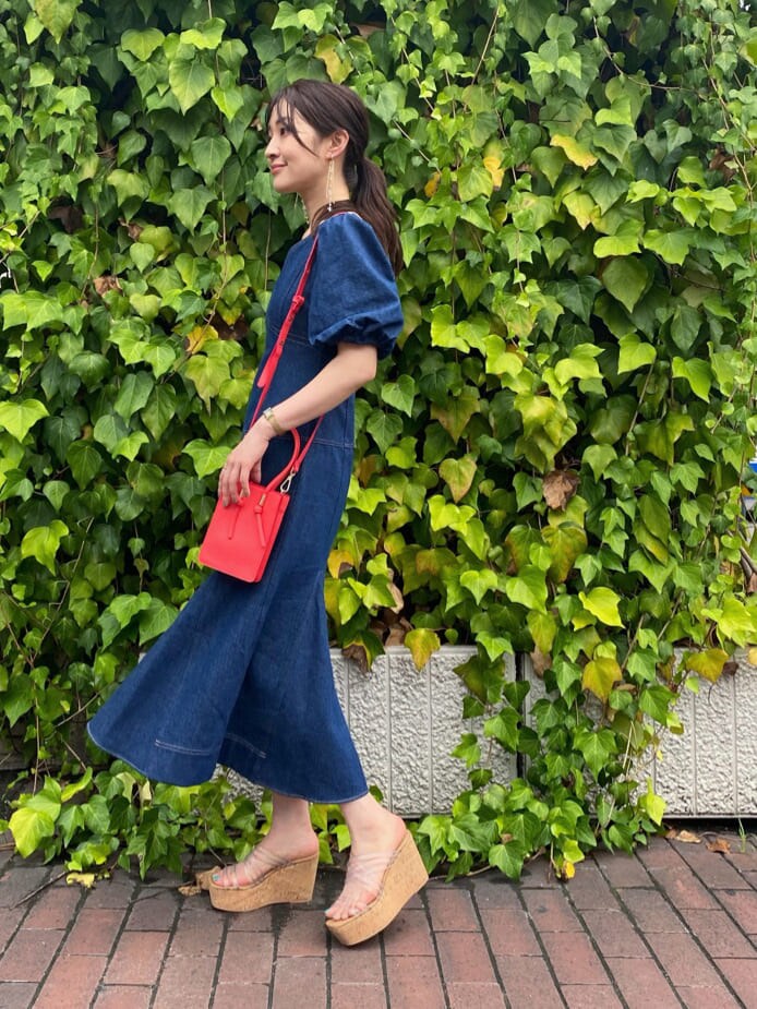 その他のサンダル、ブルー系のワンピース、レッド系のハンドバッグを着用したレディースの夏コーディネートの3枚目の写真