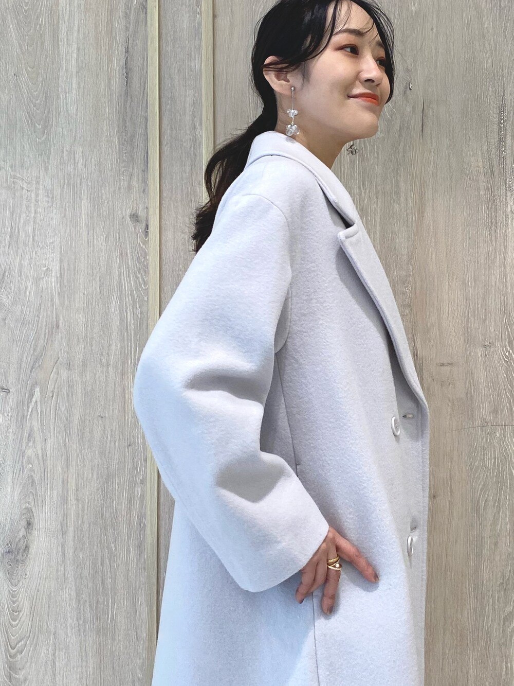 ベージュ系のブーツ、ピンク系のチェスターコート、ブラック系のワンピースを着用したレディースの冬コーディネートの7枚目の写真