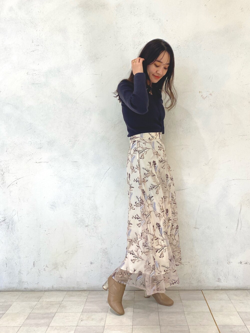 ブラウン系のニット/セーター、ピンク系のスカート、ベージュ系のブーツを着用したレディースの秋コーディネートの2枚目の写真