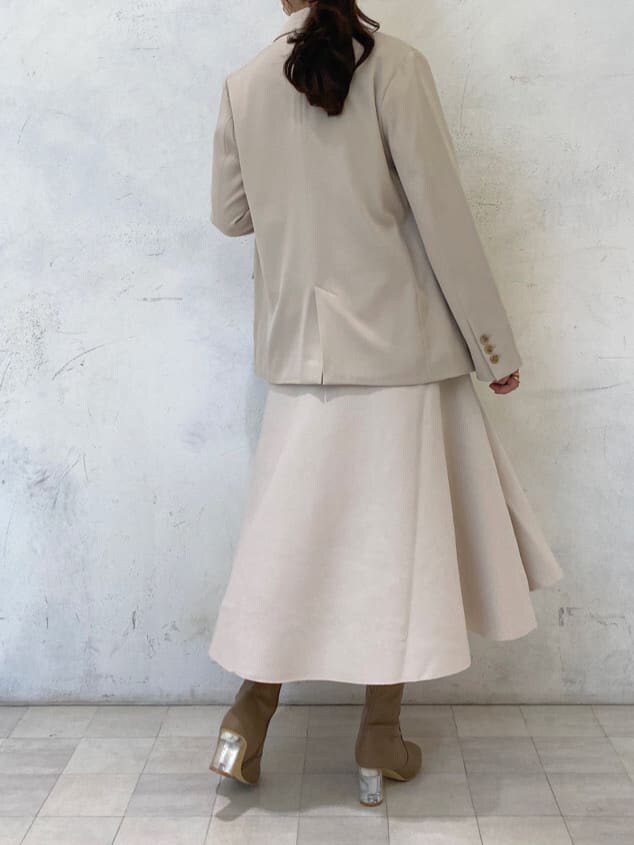 ベージュ系のブーツ、ベージュ系のテーラードジャケット、ホワイト系のワンピースを着用したレディースの秋コーディネートの4枚目の写真