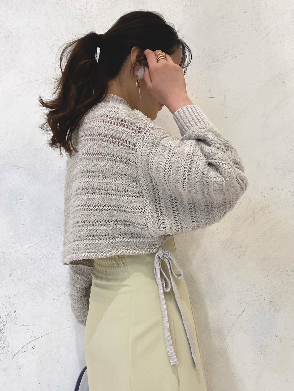 ホワイト系のローファー、イエロー系のスカート、ブルー系のハンドバッグを着用したレディースの冬コーディネートの7枚目の写真