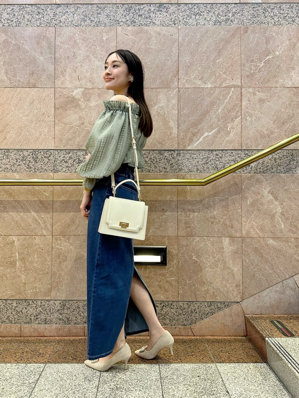 グリーン系のシャツ/ブラウス、ブルー系のデニムスカート、ベージュ系のパンプスを着用したレディースの冬コーディネートの3枚目の写真