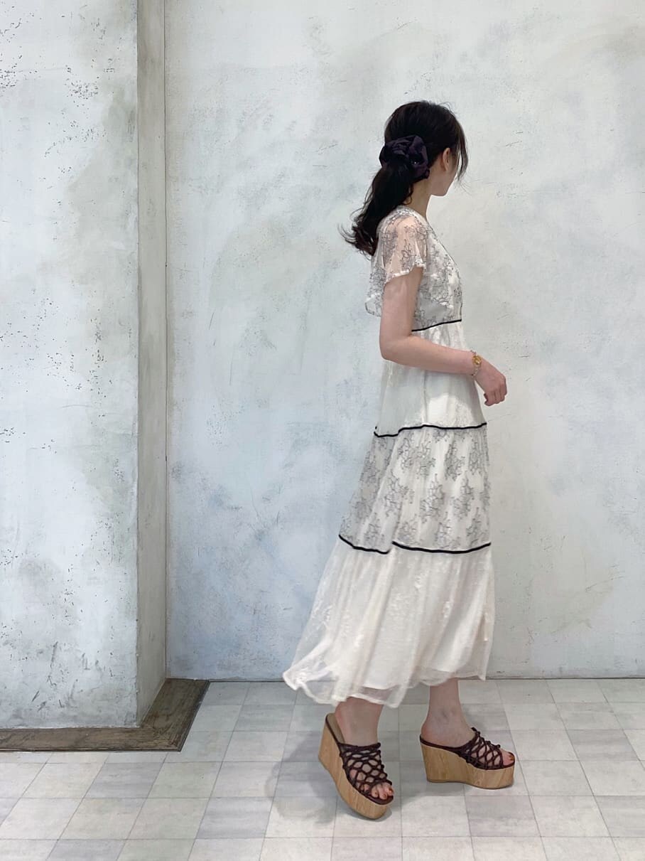 ベージュ系のTシャツ/カットソー、ホワイト系のワンピース、ブラウン系のサンダルを着用したレディースの夏コーディネートの2枚目の写真