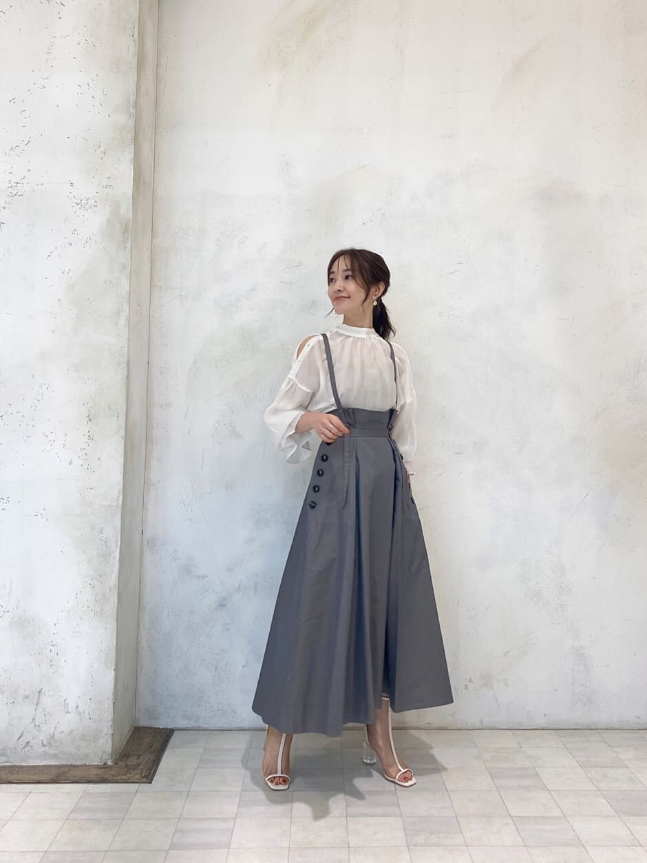 ホワイト系のシャツ/ブラウス、ベージュ系のスカート、ベージュ系のハンドバッグを着用したレディースの夏コーディネートの2枚目の写真