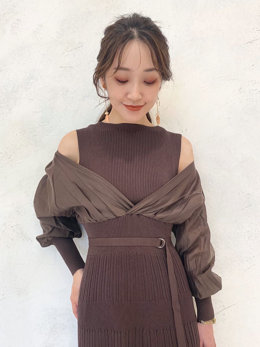 ベージュ系のハンドバッグ、ベージュ系のブーツ、ブラウン系のワンピースを着用したレディースの秋コーディネートの5枚目の写真