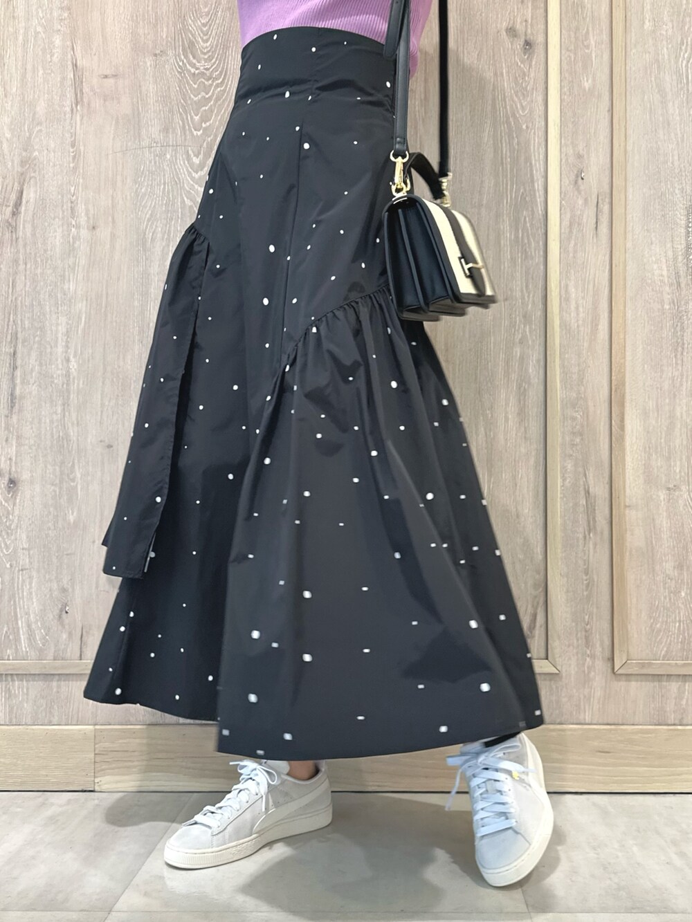 ピンク系のニット/セーター、その他のスカート、ブラック系のハンドバッグを着用したレディースの春コーディネートの6枚目の写真