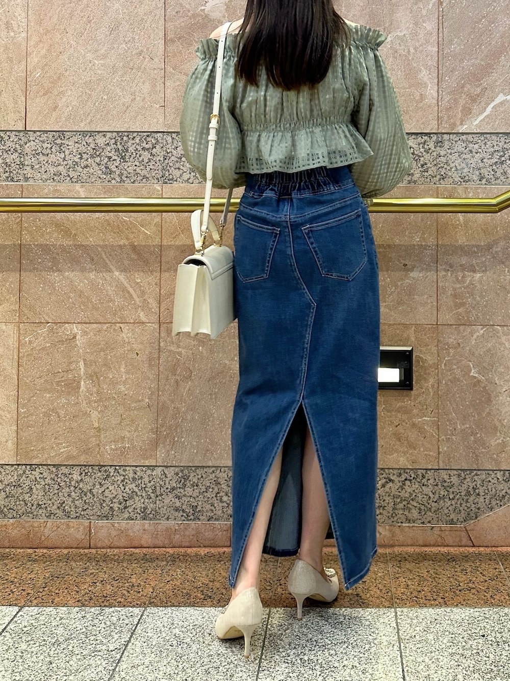 グリーン系のシャツ/ブラウス、ブルー系のデニムスカート、ベージュ系のパンプスを着用したレディースの冬コーディネートの4枚目の写真