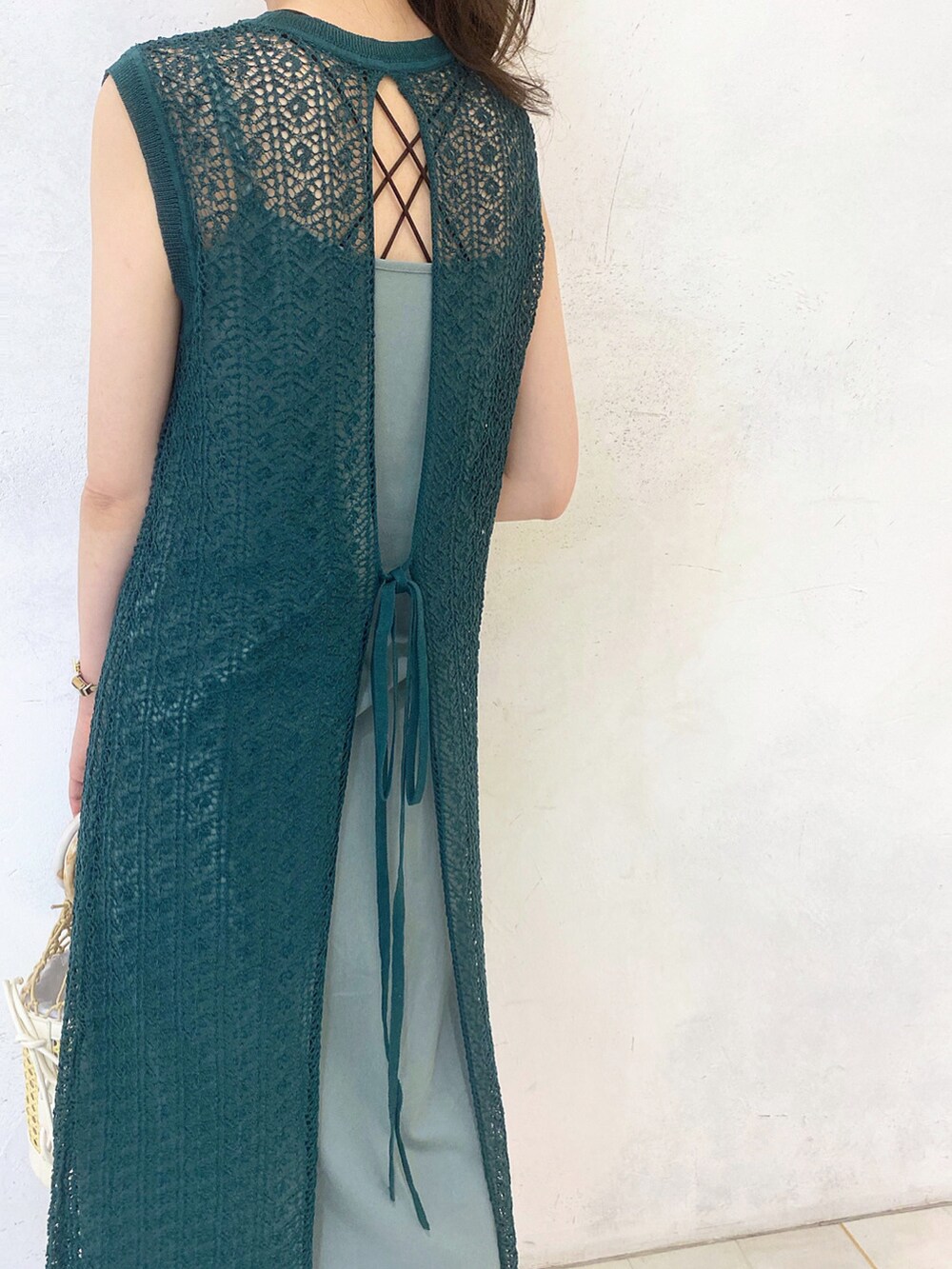 ホワイト系のサンダル、グリーン系のワンピース、ホワイト系のハンドバッグを着用したレディースの春コーディネートの5枚目の写真