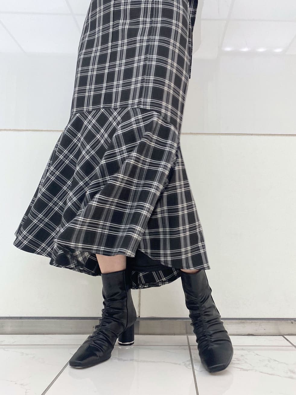 ブラック系のニット/セーター、ブラック系のその他シューズ、ブラック系のスカートを着用したレディースの秋コーディネートの7枚目の写真