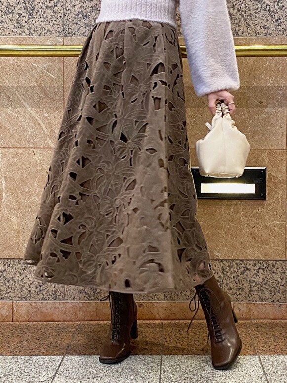 ホワイト系のハンドバッグ、パープル系のニット/セーターを着用したレディースの冬コーディネートの5枚目の写真