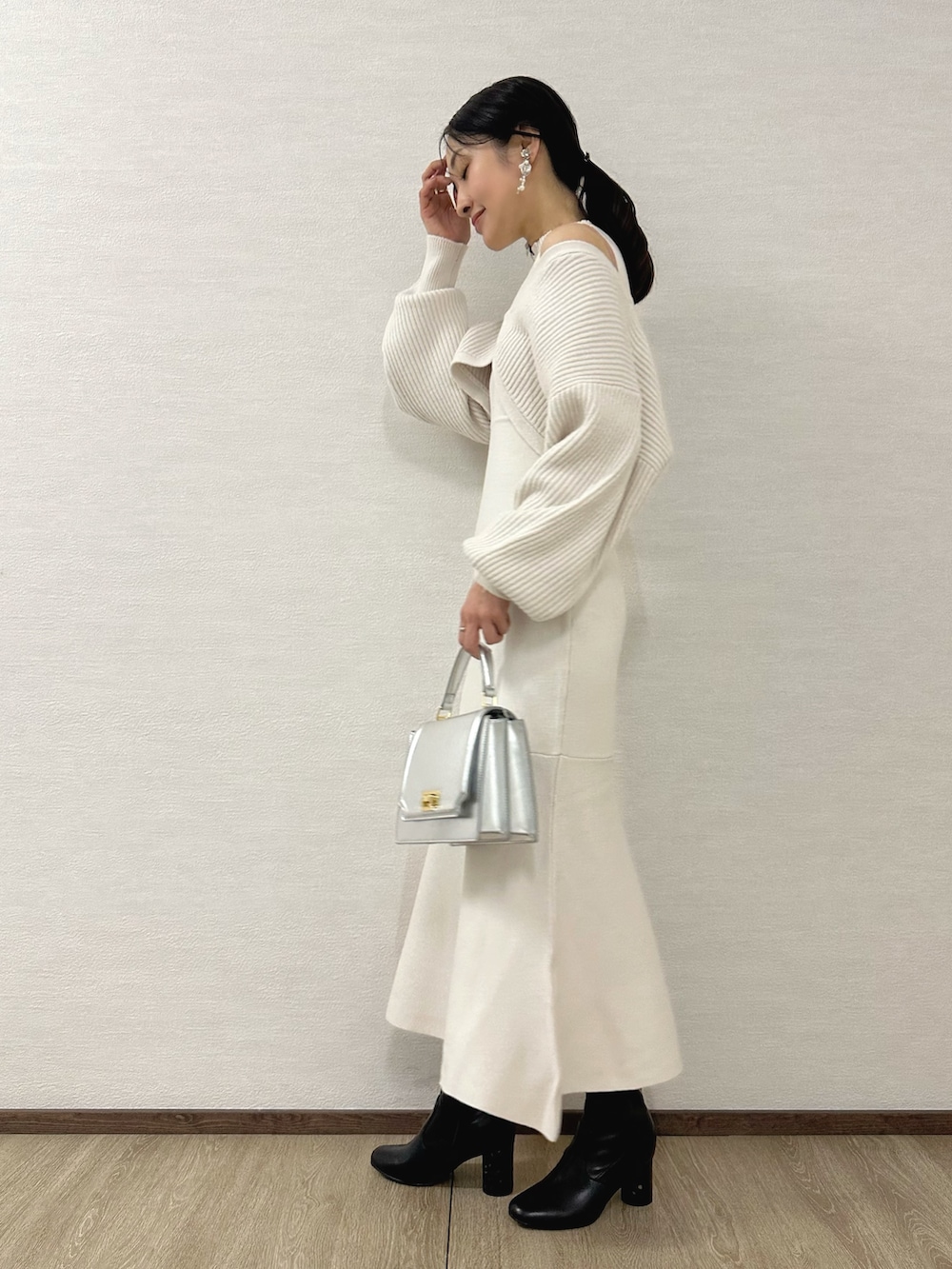 ホワイト系のワンピース、シルバー系のハンドバッグ、ブラック系のブーツを着用したレディースの秋コーディネートの3枚目の写真