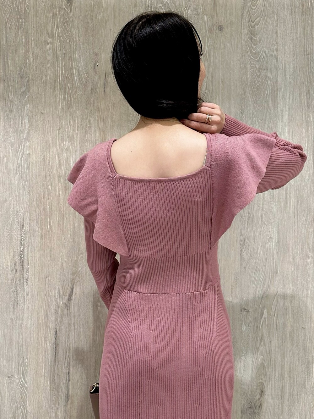 ピンク系のワンピース、ブラウン系のハンドバッグ、ブラウン系のブーツを着用したレディースの冬コーディネートの7枚目の写真