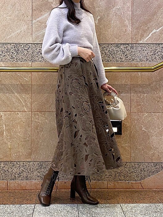 ホワイト系のハンドバッグ、パープル系のニット/セーターを着用したレディースの冬コーディネートの3枚目の写真