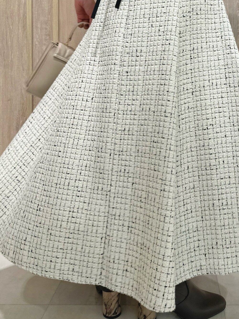 ホワイト系のスカート、ブルー系のカーディガン/ボレロ、ブラウン系のブーツを着用したレディースの秋コーディネートの10枚目の写真