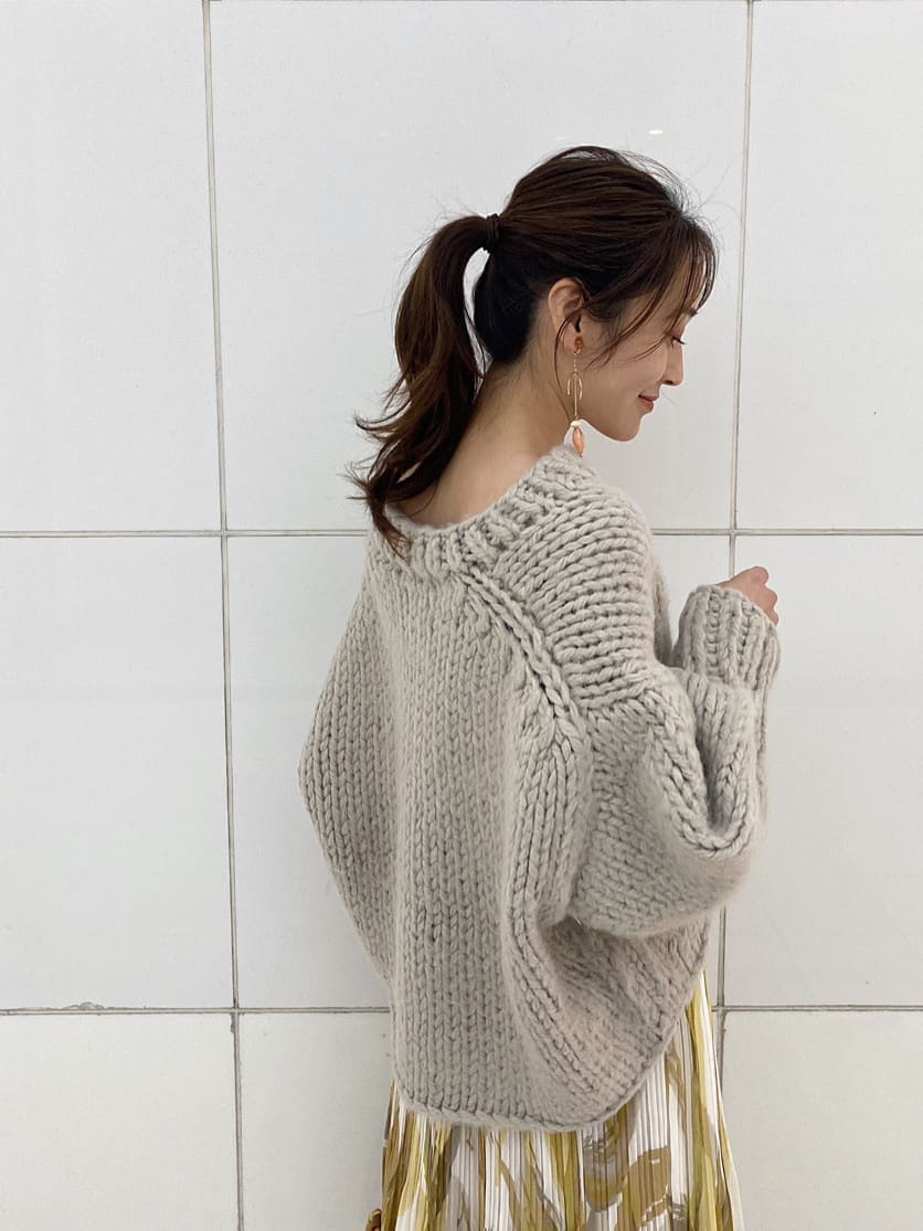 イエロー系のスカート、グレー系のニット/セーター、ベージュ系のブーツを着用したレディースの秋コーディネートの8枚目の写真