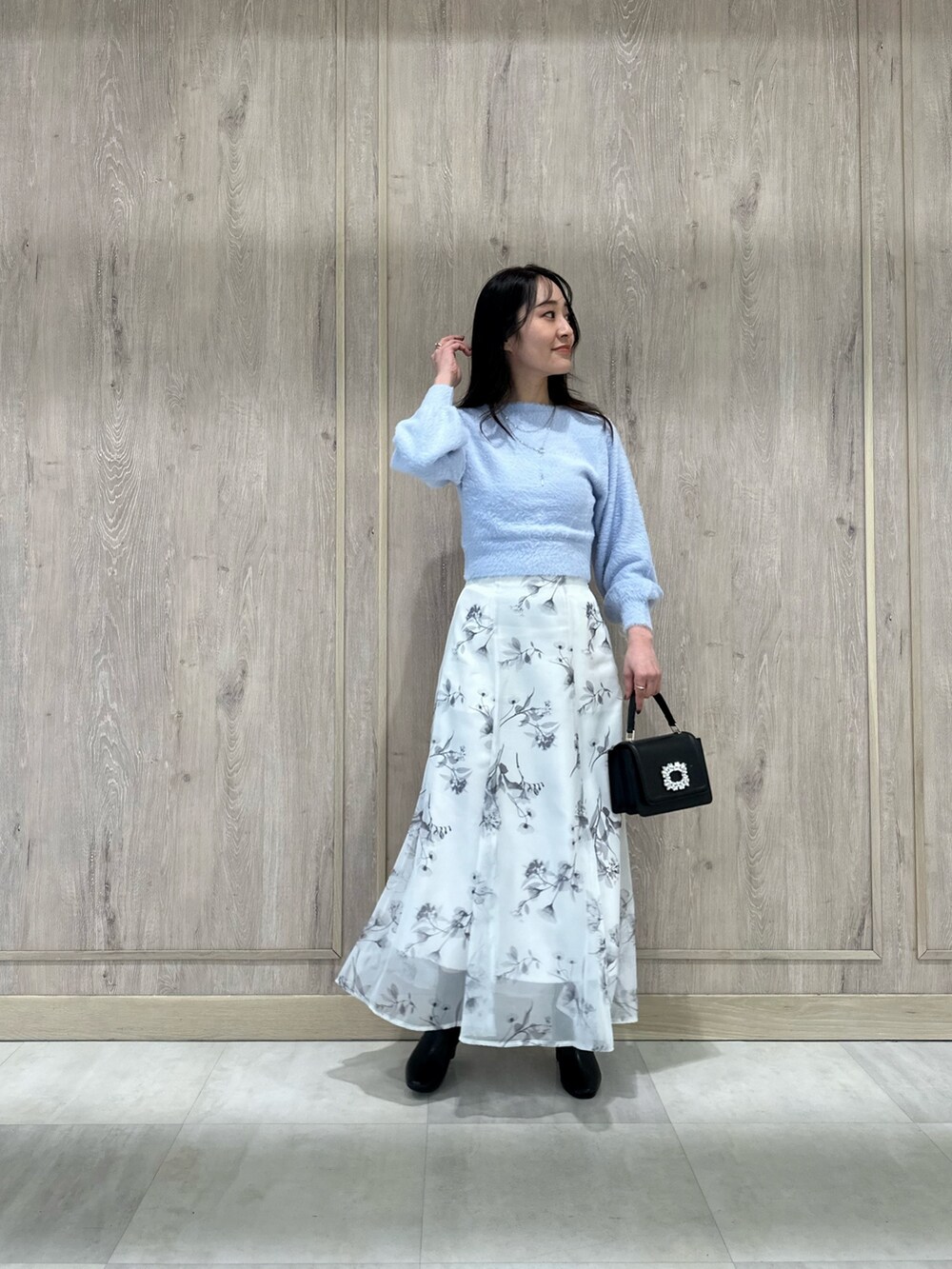 ブラック系のブーツ、ブラック系のショルダーバッグ、ブルー系のカーディガン/ボレロを着用したレディースの冬コーディネートの2枚目の写真