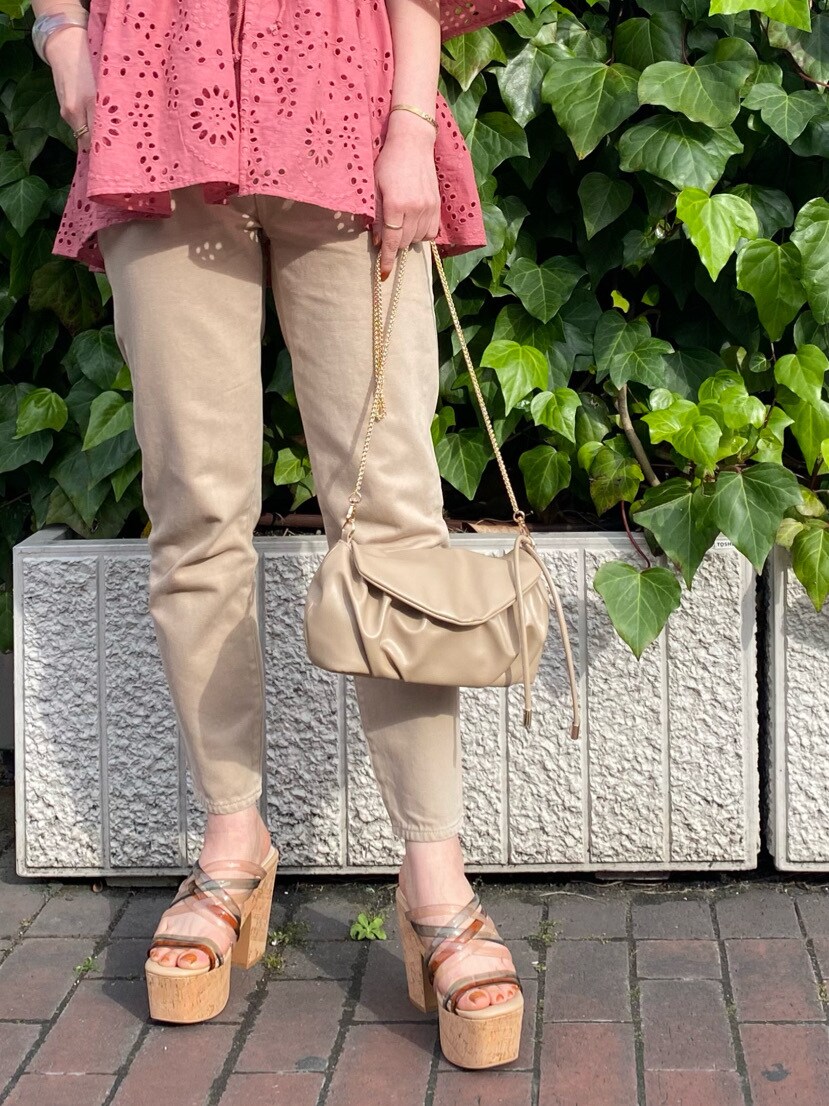 ベージュ系のその他パンツ、グリーン系のサンダル、ベージュ系のクラッチバッグを着用したレディースの春コーディネートの5枚目の写真