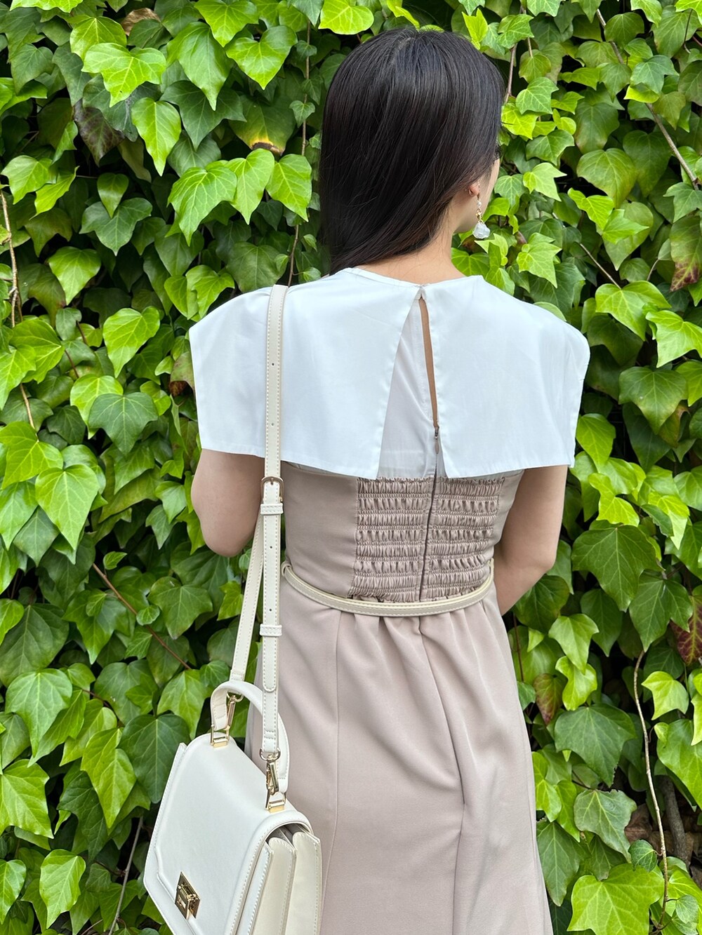 その他のサンダル、ホワイト系のハンドバッグ、ベージュ系のワンピースを着用したレディースの春コーディネートの6枚目の写真