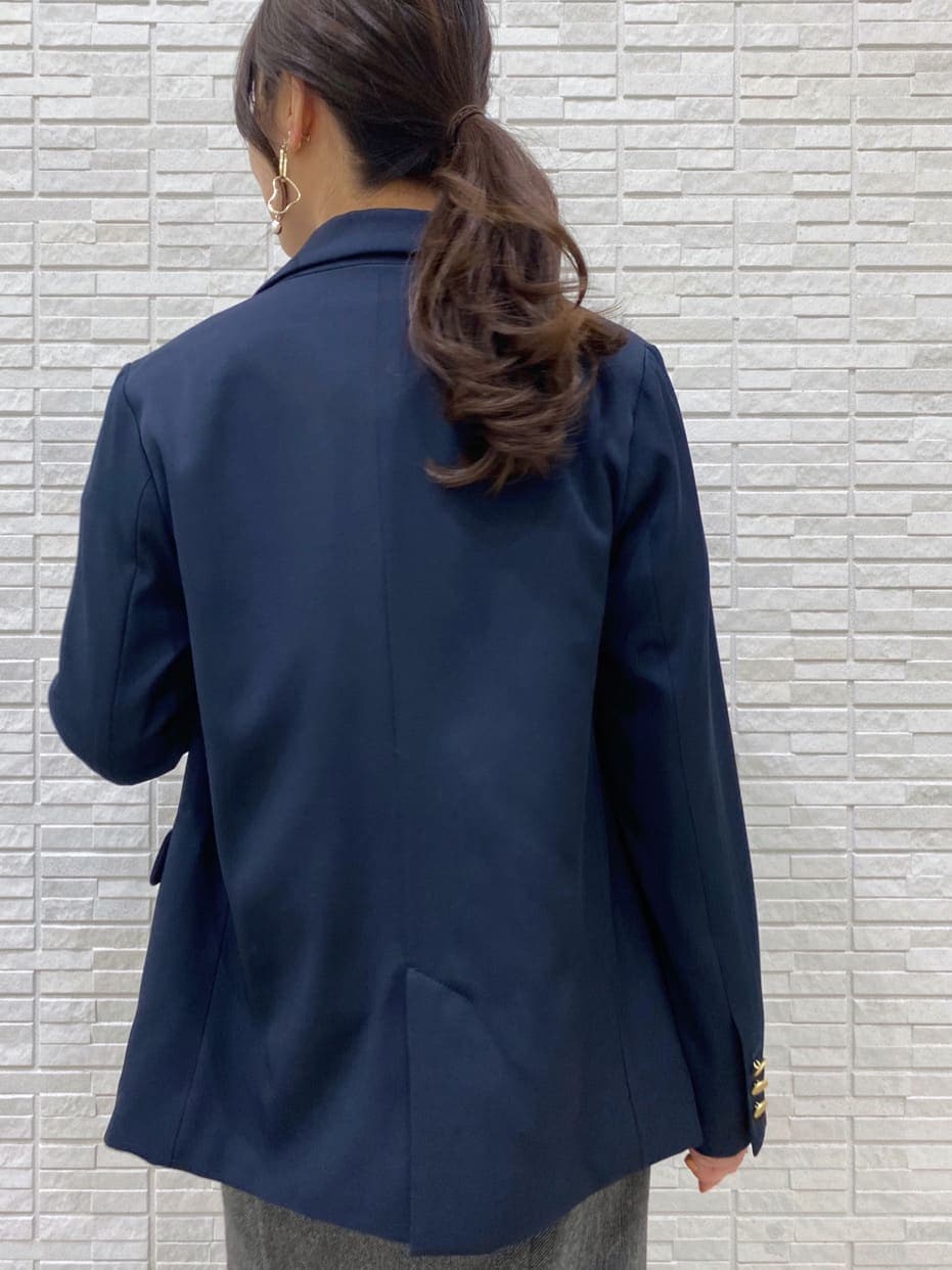 ブラック系のブーツ、ブルー系のテーラードジャケット、グレー系のスカートを着用したレディースの秋コーディネートの6枚目の写真