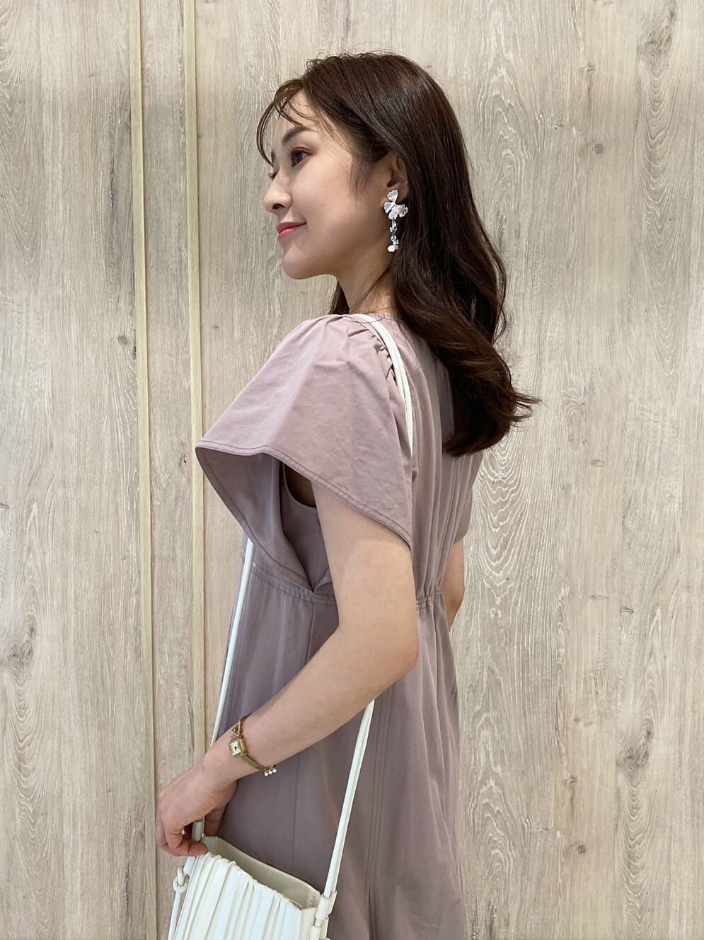 ベージュ系のワンピース、ホワイト系のサンダル、ホワイト系のハンドバッグを着用したレディースの夏コーディネートの6枚目の写真