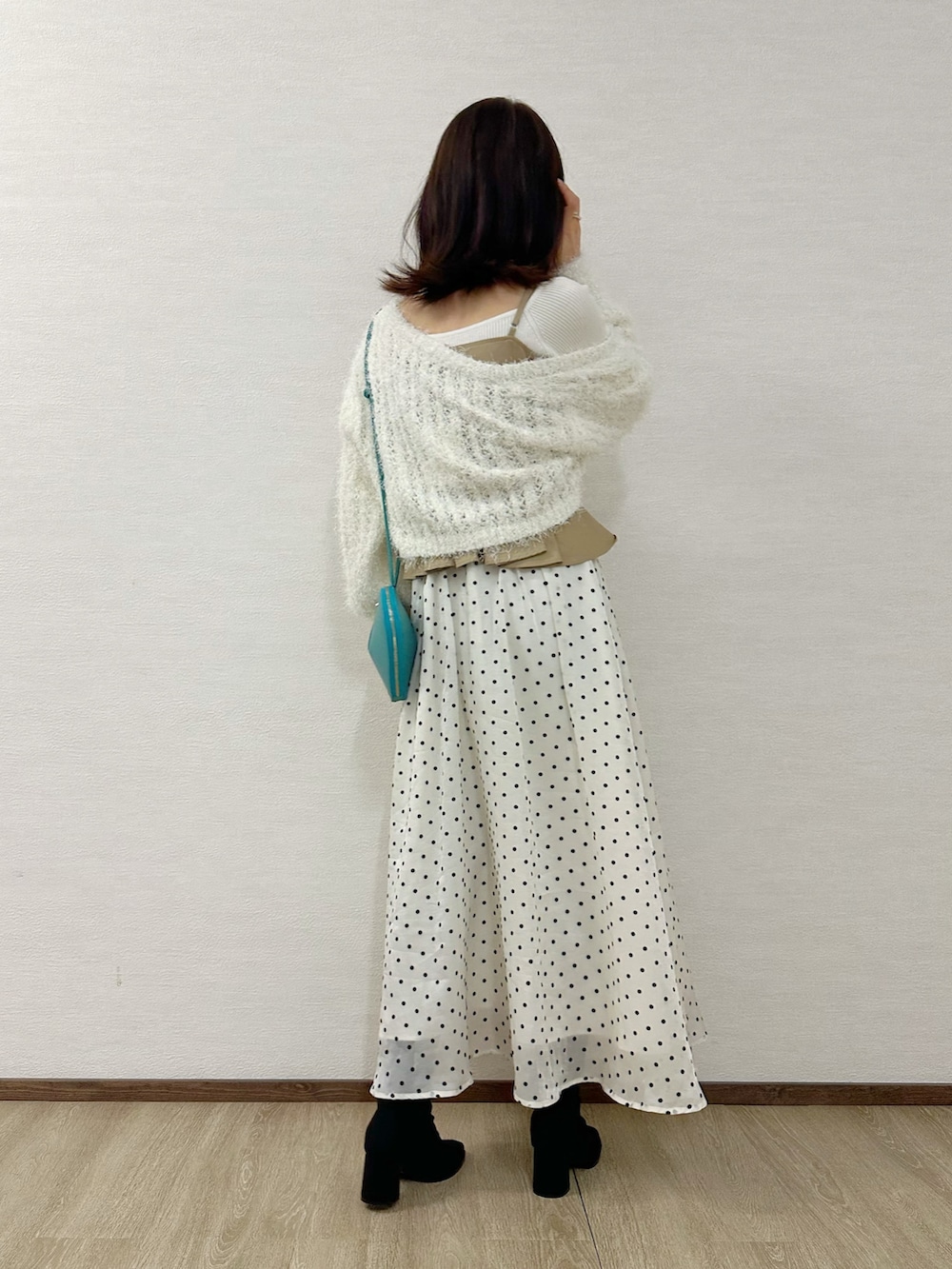 ホワイト系のカーディガン/ボレロ、ベージュ系のワンピース、ホワイト系のニット/セーターを着用したレディースの秋コーディネートの3枚目の写真