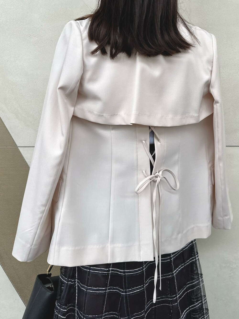 ブラック系のハンドバッグ、ブラック系のスカート、その他のサンダルを着用したレディースの春コーディネートの7枚目の写真