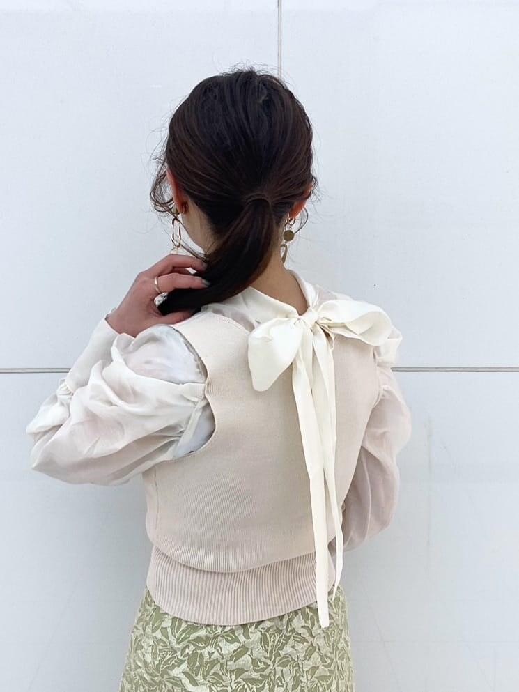 ベージュ系のパンプス、グリーン系のスカート、イエロー系のショルダーバッグを着用したレディースの冬コーディネートの8枚目の写真