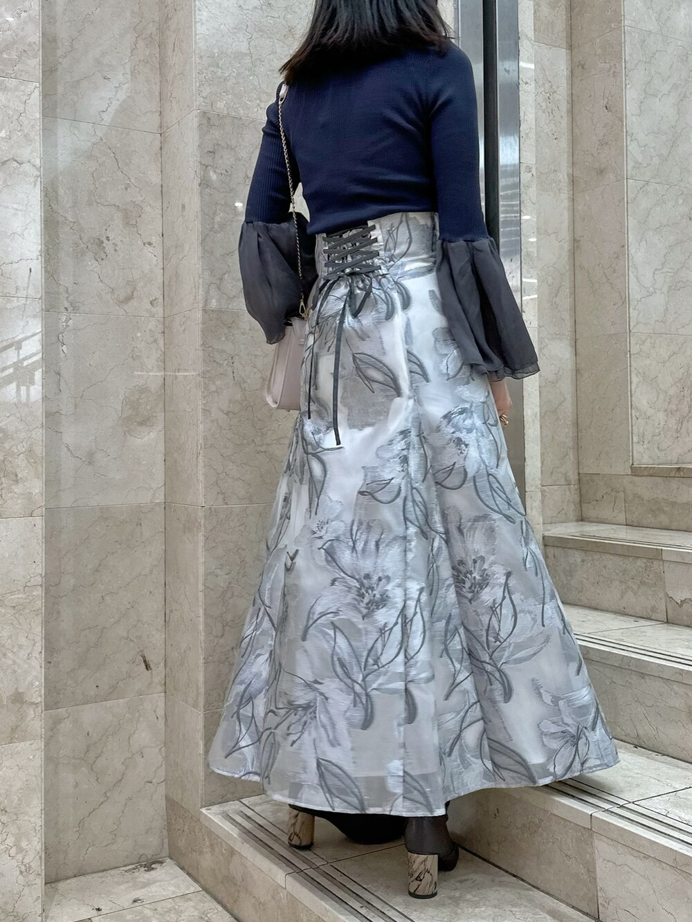 ブラウン系のブーツ、ピンク系のショルダーバッグ、グレー系のニット/セーターを着用したレディースの春コーディネートの4枚目の写真