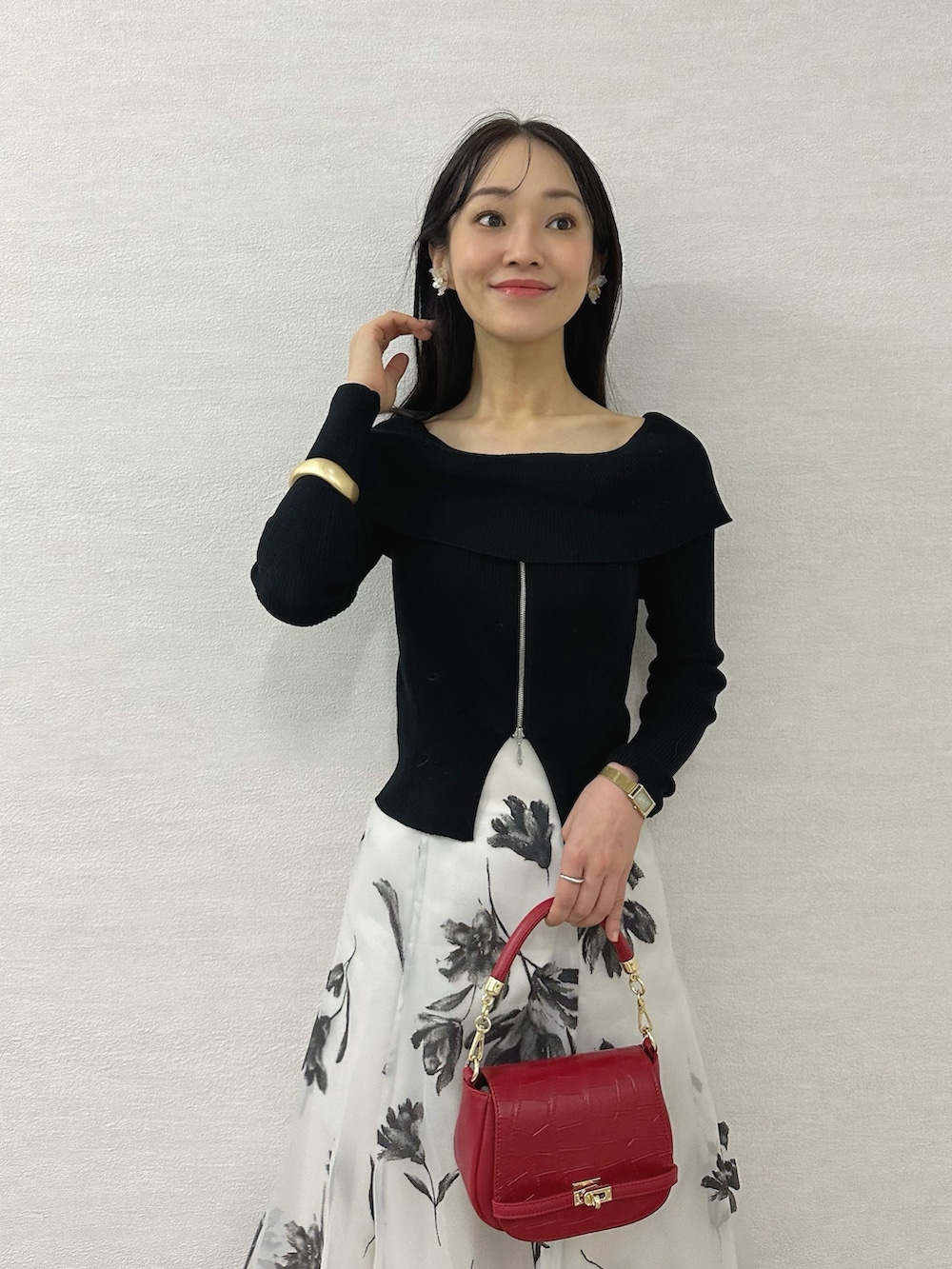 ブラック系のニット/セーター、ブラック系のブーツ、レッド系のハンドバッグを着用したレディースの秋コーディネートの5枚目の写真