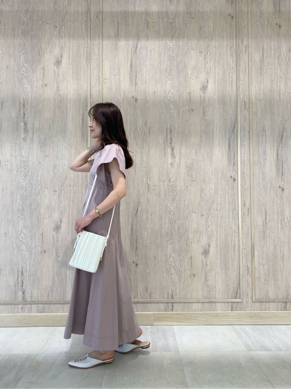 ベージュ系のワンピース、ホワイト系のサンダル、ホワイト系のハンドバッグを着用したレディースの夏コーディネートの3枚目の写真