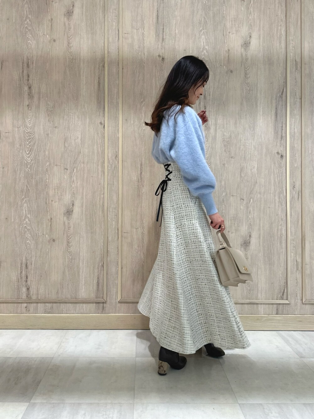 ホワイト系のスカート、ブルー系のカーディガン/ボレロ、ブラウン系のブーツを着用したレディースの秋コーディネートの3枚目の写真