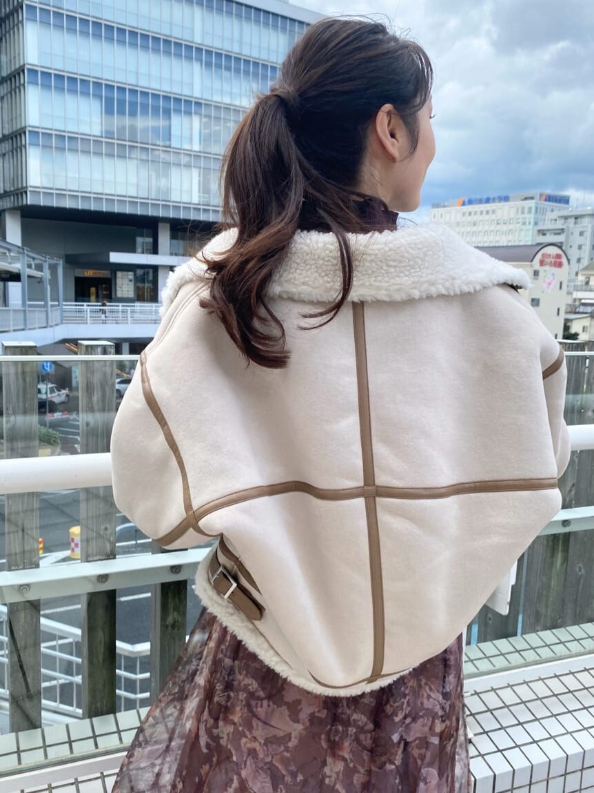 ベージュ系のブーツ、ベージュ系のムートンコート、ブラウン系のニット/セーターを着用したレディースの秋コーディネートの9枚目の写真