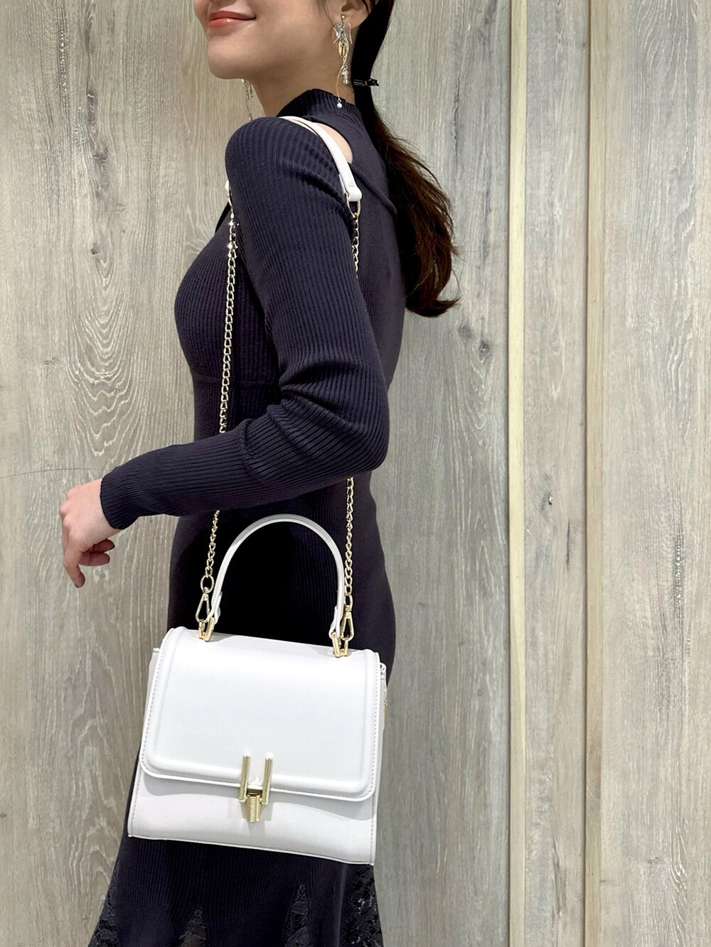 ブラウン系のブーツ、グレー系のワンピース、ピンク系のショルダーバッグを着用したレディースの冬コーディネートの7枚目の写真